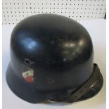 A WW2 German style helmet, painted blue with applied crest and flag to the sides