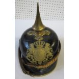 A pickelhaube style helmet, with pointed gilt spike, decorated with a gilt crest to the front