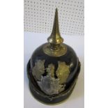 A pickelhaube style helmet, with pointed gilt spike, decorated with a gilt eagle and shield crest to