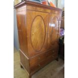 A Georgian mahogany linen press, having two oval cross banded panel doors, opening to reveal hanging