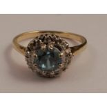 An blue zircon and diamond cluster ring, the brilliant cut zircon to the centre, diameter 5mms, in