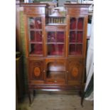 An Edwardian mahogany display cabinet, having three glazed doors with lower central gallery, over