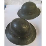 Two metal WW1 helmets, having impressed marks to the rims