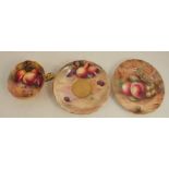 A Royal Worcester trio, the interior of the cup painted with fruit to a mossy background by