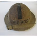 A WW2 metal helmet, with black stripe and the words "1st Aid Post", impressed JSS BV 1939