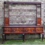 A late Georgian dresser, with open delft rack over, fitted with two cupboards, and having two long