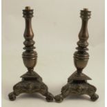 A pair of 17th century German bronze candlestick bases with multi knop stems, to a triangular base