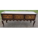 An oak dresser base, fitted with three drawers above an shaped apron, raised on cabriole legs, width