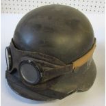 A WW2 German style helmet, decorated with an eagle and swastika crest, together with a pair of