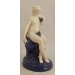 A Royal Worcester figure of a naked girl, seated on a Sabrina blue naturalistic outcrop, height