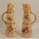 A pair of Royal Worcester blush ivory claret jugs, decorated with floral sprays and having gilt