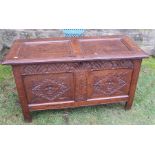 An oak coffer, having two carved panels to the front and two plan panels to the lid, width 43ins