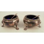 A pair of silver plated open salts, of circular form with bead edge, raised on three scroll legs,