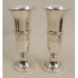 A pair of silver vases, with flared rims, ribbed body and raised on circular pedestal base, with