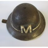 A WW2 black metal messenger's helmet, with a painted white band and "M" to one end
