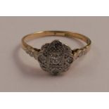 An 18 carat gold and platinum diamond set cluster ring, the flower shaped head set with five