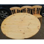 A pine circular table, together with three pine kitchen chairs