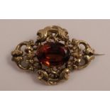 A Victorian yellow metal brooch, ornate set with a large oval citrine, max 1.75ins x 2.25ins, 13.