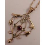 A 9 carat gold seed pearl and garnet pendant, the filigree pendant set with four seed pearls and a