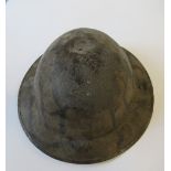 A WW2 metal helmet, painted in camouflage colours, indistinctly stamped to the rim FSI7N