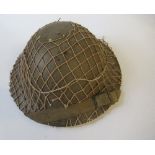 A WW2 metal helmet, with netting cover