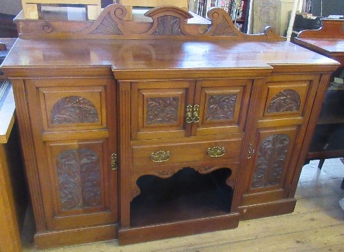 An Edwardian mahogany break front side board, fitted with a cupboard, over a drawer, over a shelf,