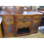 An Edwardian mahogany break front side board, fitted with a cupboard, over a drawer, over a shelf,