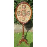 An early 19th century walnut tapestry pole screen, the oval tapestry in a frame with carved