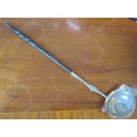 A silver toddy ladle, with twisted porcupine handle, the lipped bowl set with a coin dated 1758