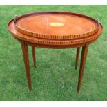 A mahogany and satinwood inlay oval table, the top with galleried sides, raised on square tapering
