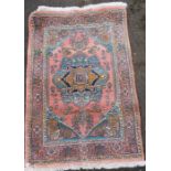 An Eastern design rug, with coral ground, 38ins x 56ins