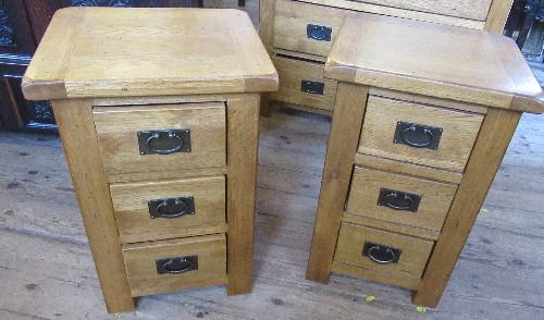 A pair of modern oak bedside cabinets, fitted with three drawers, 16ins x 18is x height 27.5ins