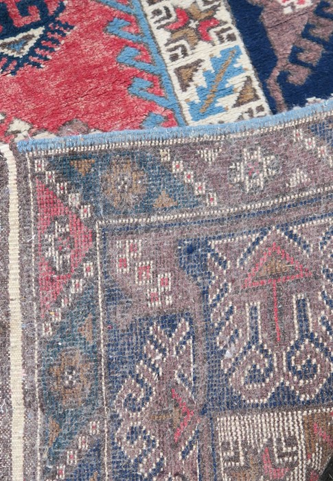 An Eastern style rug, having red medallions, and three lozenge motifs to a blue border, 80ins x - Image 2 of 3