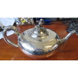 A silver tea pot with thistle finial, leaf moulding to the spout and handle, engraved with a