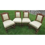 A set of four Edwardian oak dining chairs, with carved and upholstered back, raised on carved legs