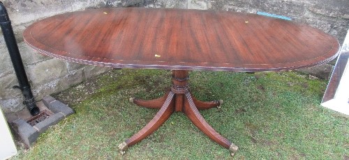 A mahogany tripod dining table, raised on a column with four reeded legs, length closed 54ins,