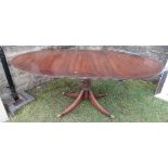 A mahogany tripod dining table, raised on a column with four reeded legs, length closed 54ins,