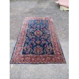 A modern blue rug, decorated in a blue ground with stylised foliage, 83ins x 51ins