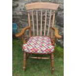 A Windsor style open armchair, with stick back, having turned supports to the shaped arms