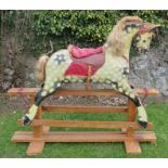 A carved and painted rocking horse, dapple grey horse, with leather and upholstered saddle, on a