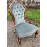 A Victorian show wood nursing chair, with carved and button spoon back, raised on short cabriole