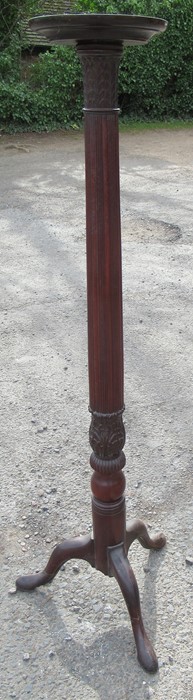 A mahogany torchere, with carved column, raised on three outswept supports, height 60ins