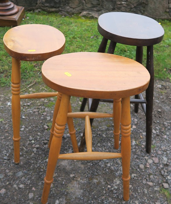 Three oval topped stools, height 21.5ins and 24ins