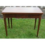 A 19th century mahogany fold over tea table, with satinwood stringing, raised on square tapering