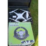 A Phantom boxed drone, together with a gaming steering wheel