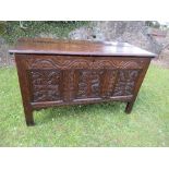 An 18th century oak coffer, with plain rising lid, the front having a carved frieze, with three