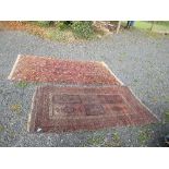 An Eastern design rug, decorated with medallions in a central field to a dark pink and brown