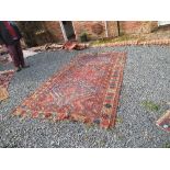 An Eastern design rug, decorated with three medallions in the central panel to a rust coloured field
