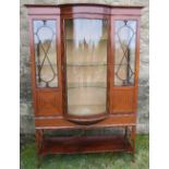 An Edwardian mahogany display cabinet, with barrel central glazed door, fitted with a shelf under,