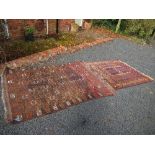 An Eastern design rug, decorated with a central panel to a cream and dark red ground 57ins x